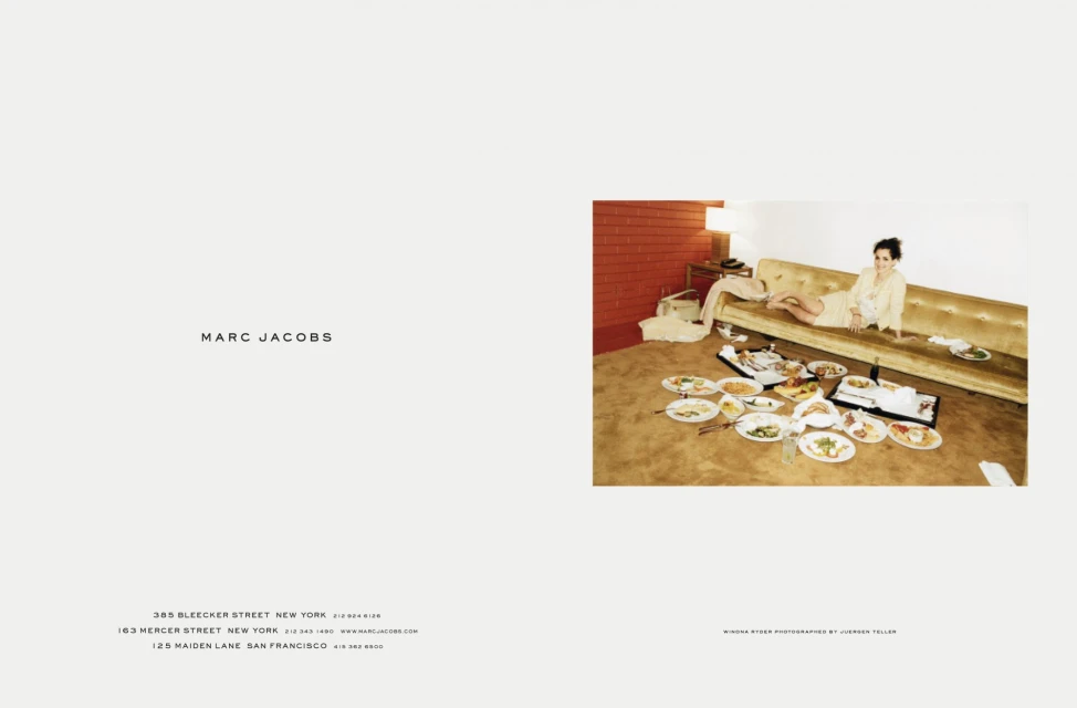Fashion editorial featuring a woman lying on a sofa, surrounded by plates of food in a messy room; styled with retro fashion aesthetic.