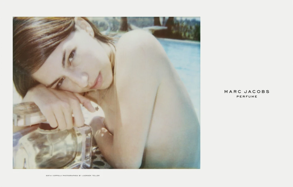 Sofia Coppola for Marc Jacobs perfume, features woman reclining near pool with product, sunlight, poolside setting, and light color palette.
