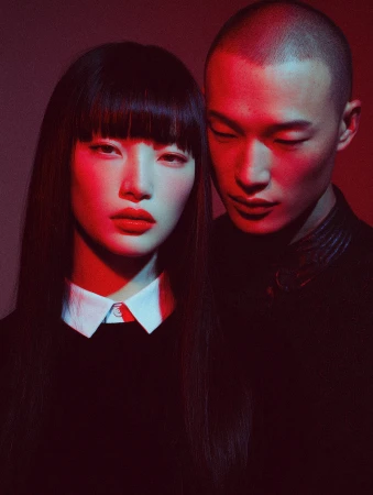 Close-up portrait of two east asian models with dramatic red and blue lighting by Victor Basco Studio