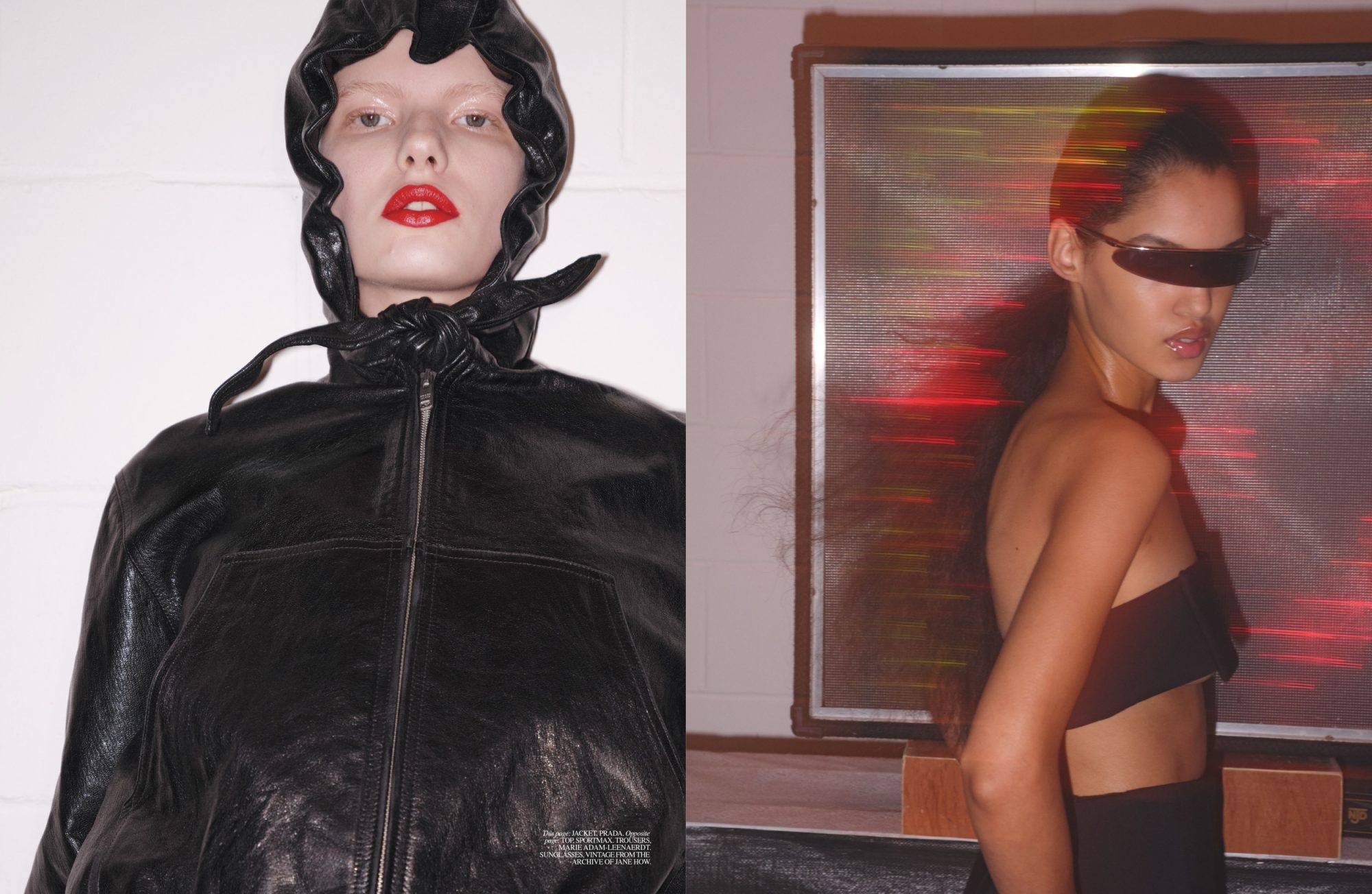 Two fashion models pose indoors: one in a black hooded jacket with red lipstick, and the other in a black top and futuristic sunglasses.