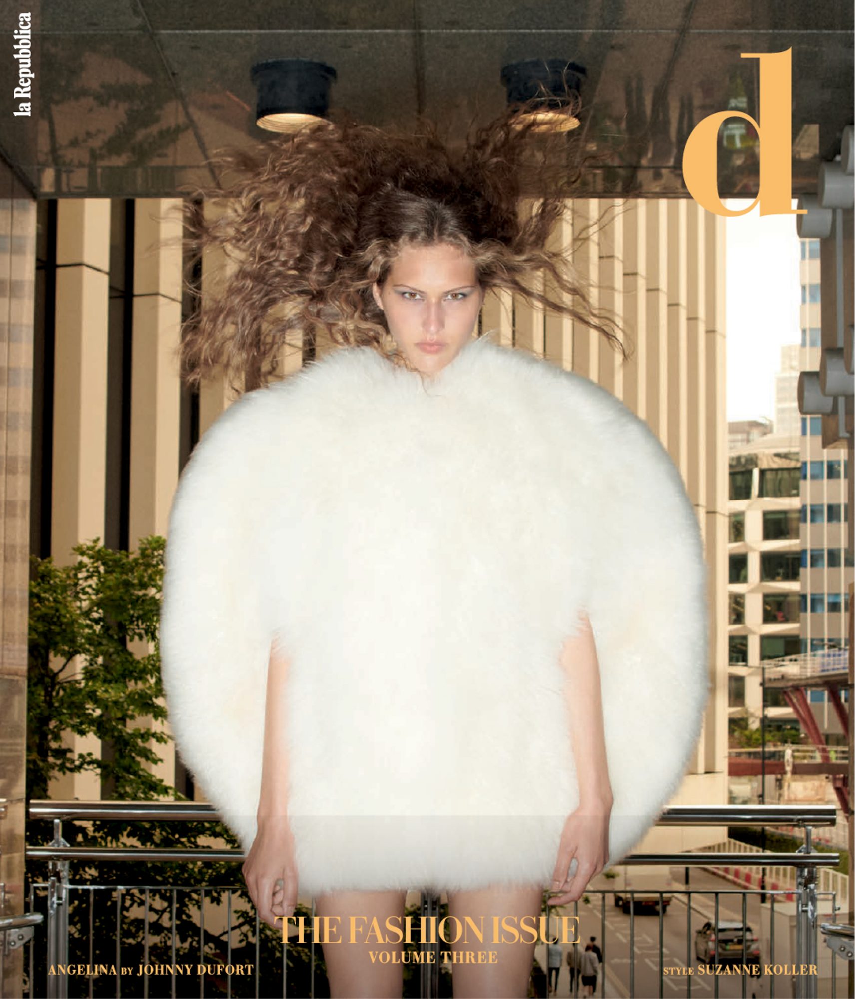 Fashion magazine cover featuring a model with curly hair wearing a large white fur coat, photographed against an urban background with tall buildings.