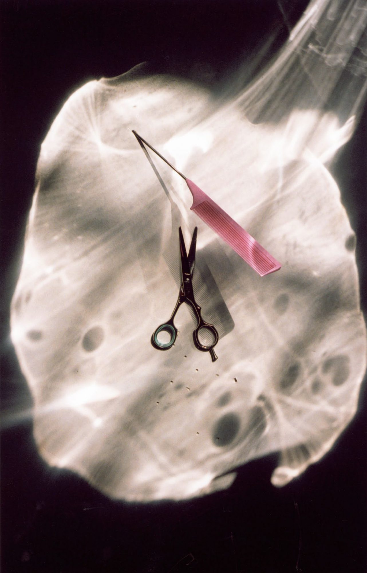 Stylized shot of a pair of scissors positioned beneath a pink pencil, set against an abstract, light-patterned backdrop. Still life.