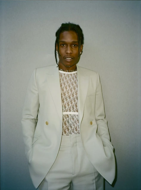 Adult male in a light suit with a sheer logo shirt, portrait shot in a photo studio, neutral background, looking at the camera.