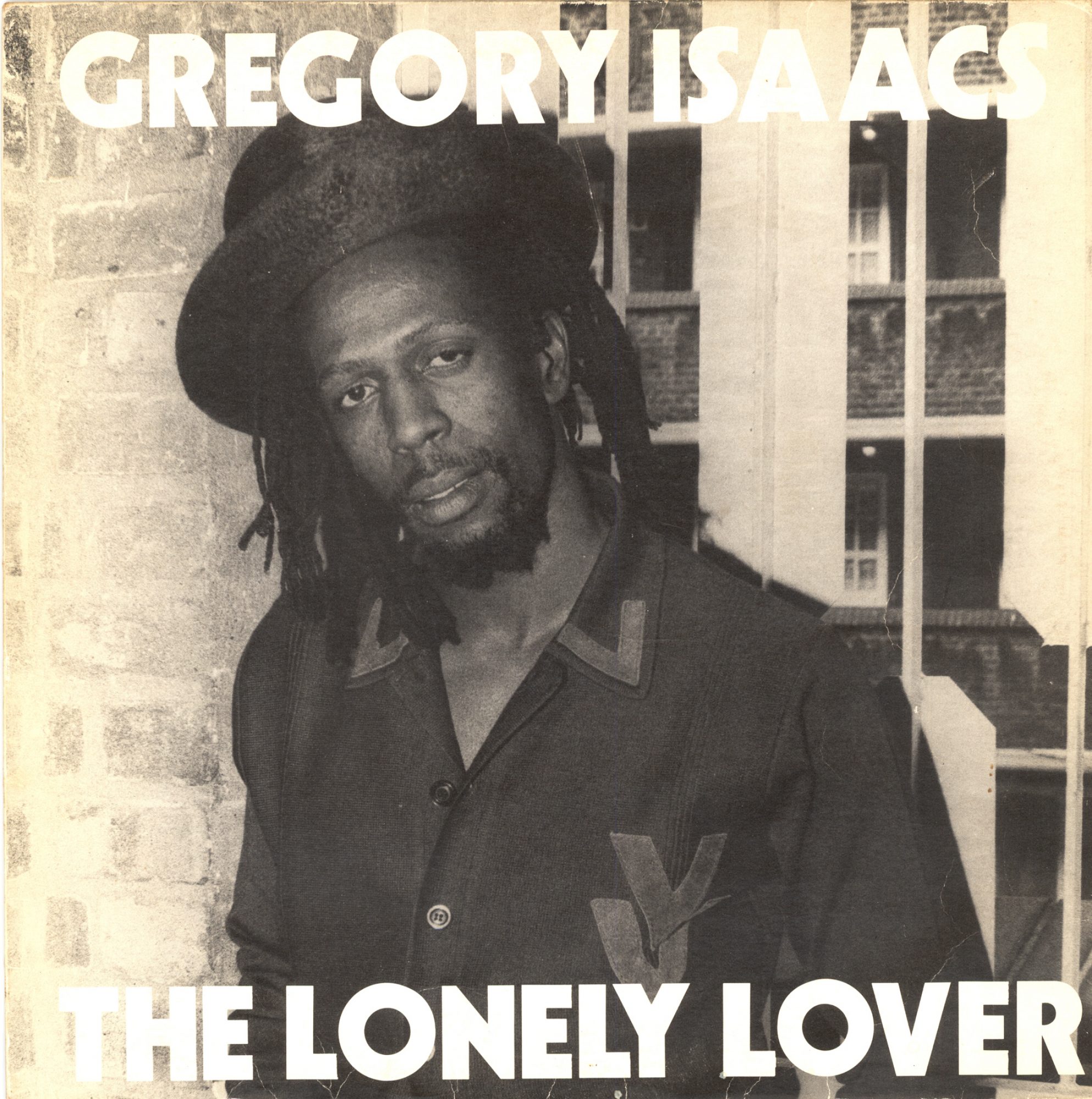 Album cover featuring Gregory Isaacs, wearing a hat and shirt, against a windowed wall, with the title 'The Lonely Lover' displayed.
