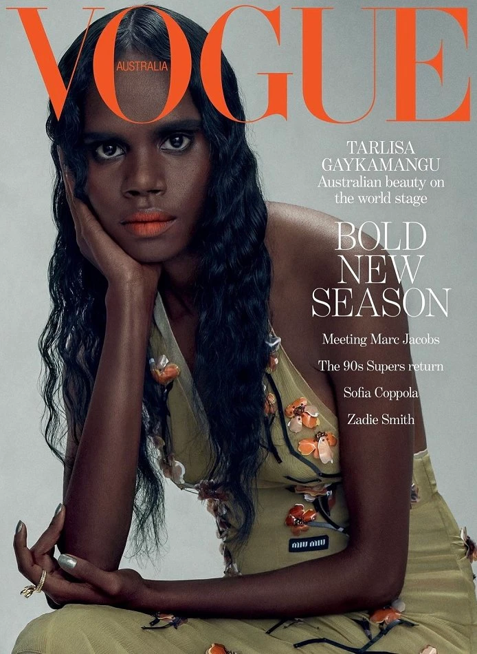 Model Tarlisa Gaykamangu featured on a magazine cover with dark wavy hair wearing a green dress against a neutral grey background