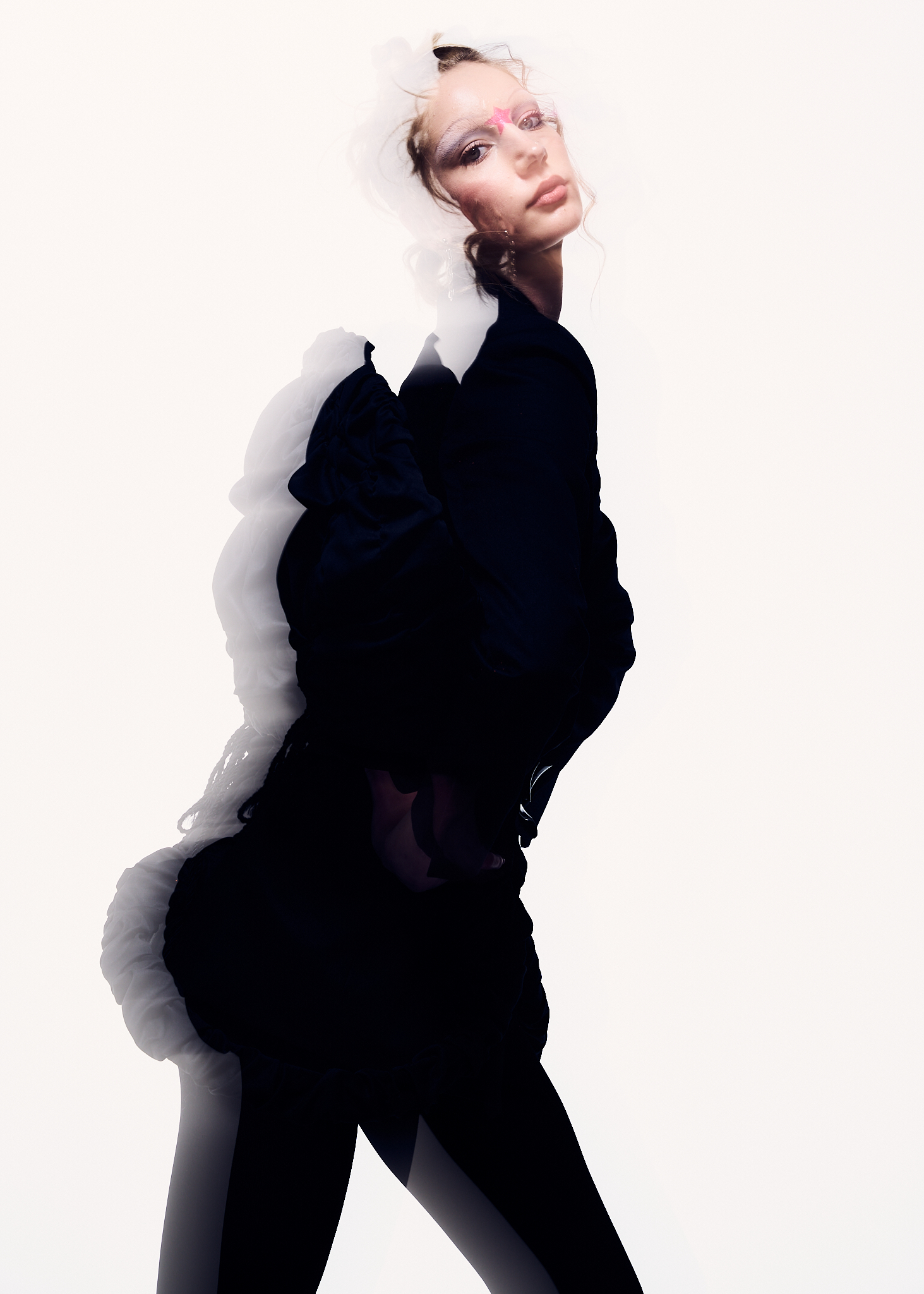 Model in black clothing against a white background with multiple exposure effect by Zach Dean