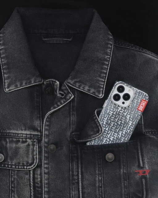 Close-up of a black denim jacket with a Diesel-branded phone case in the pocket, featuring a pattern of interlocking 'D' logos.