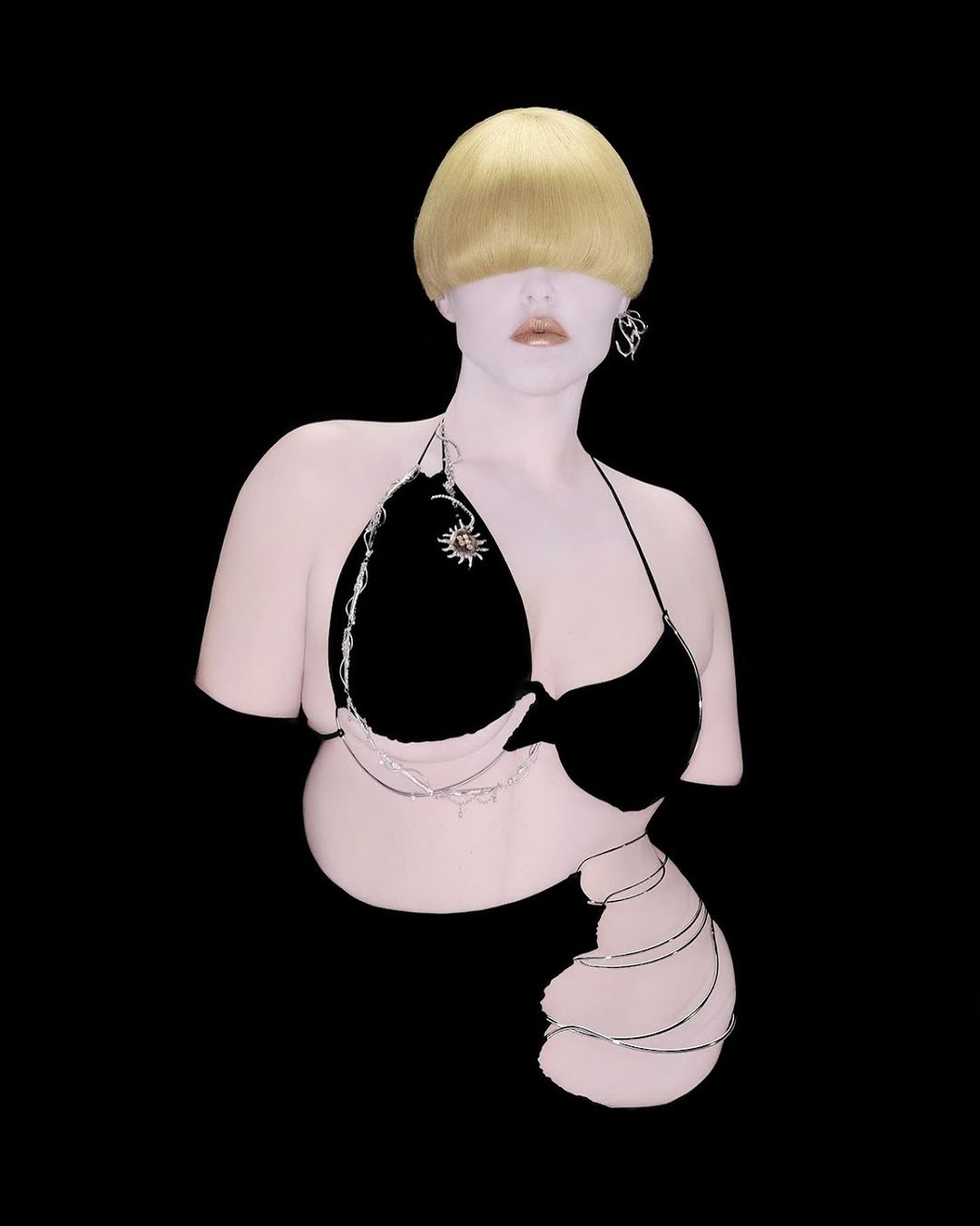 Abstract fashion shot of a blonde adult female mannequin wearing a black bikini top against a solid black backdrop in a photo studio.