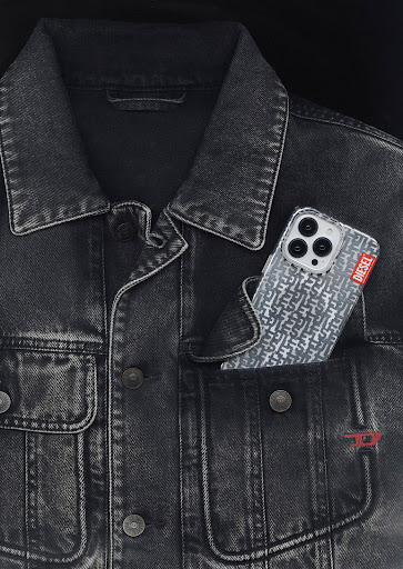 Close-up studio shot of a black denim jacket with an iPhone in the pocket, showcasing a casual fashion style and modern technology.
