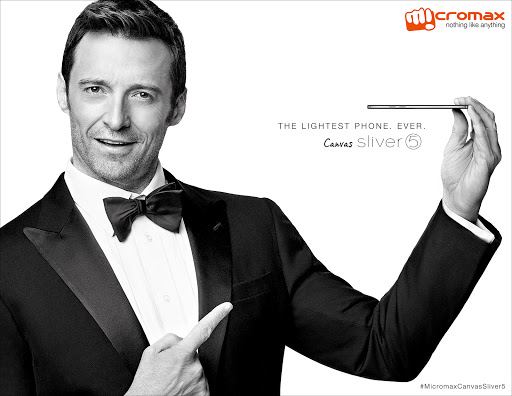 Hugh Jackman in a black tuxedo presents a Micromax Canvas Sliver 5 smartphone in a product promotion shot on a white background.