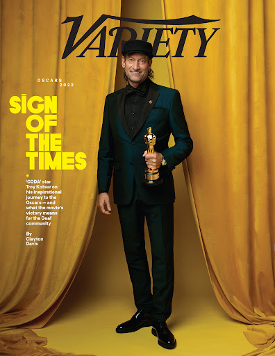 Magazine cover featuring Troy Kotsur holding an Oscar, wearing a green suit against a draped golden background. 'Variety' logo visible.