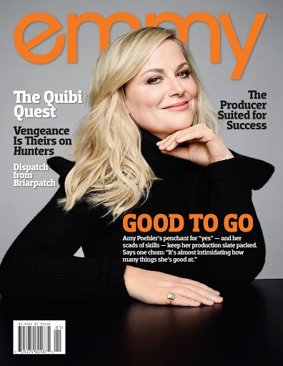 Magazine cover featuring Amy Poehler in a black turtleneck sweater with orange text, set against a grey backdrop, with articles listed.
