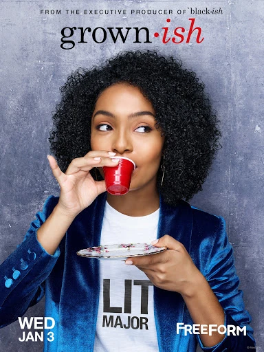 Yara Shahidi sips from a red plastic cup while holding a saucer in a promotional shot for the TV show Grown-ish against a grey background.
