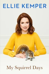 Portrait of actress Ellie Kemper wearing a mustard yellow top with a squirrel resting on a white table in front of her.