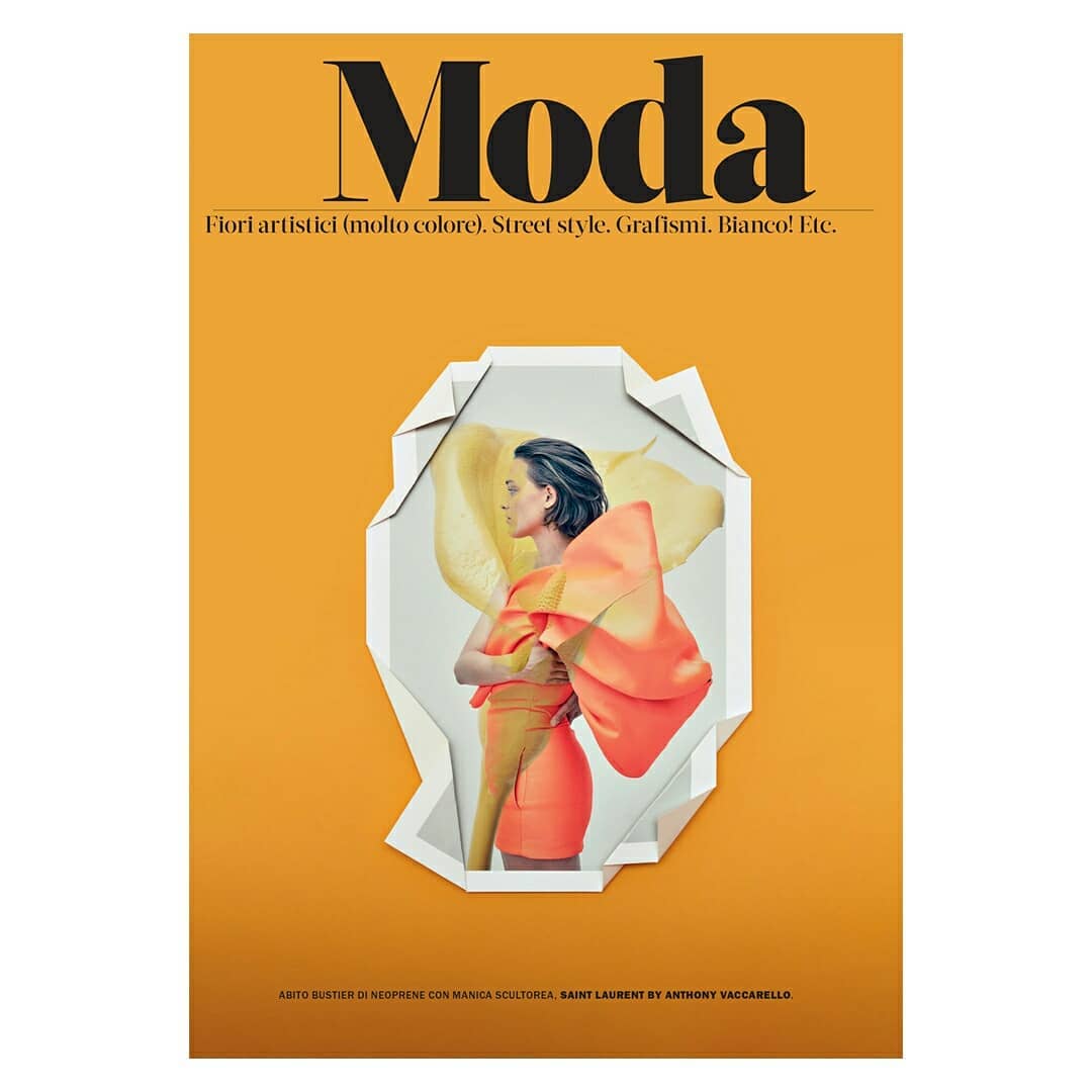 Fashion magazine cover featuring a woman in a bright orange dress with a large sculptural element, set against a yellow gradient background.