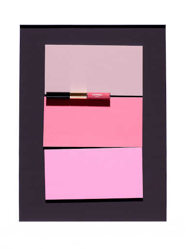 Elevated studio shot of Chanel lip gloss on pink colored panels in black frame on white. Beauty and fashion advertising concept.