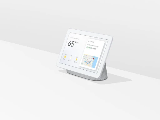 Smart home display device showcasing weather and commute information on a minimalist white surface in a brightly lit interior setting.
