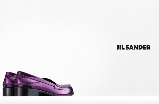 Studio shot of shiny purple Jil Sander penny loafers on a white surface with a bright white background and clear Jil Sander branding.