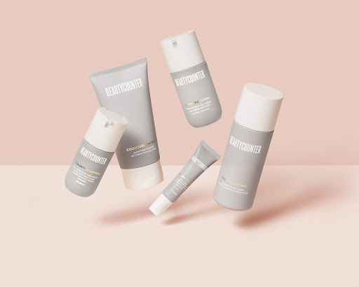 Five gray and white Beautycounter Counter+Control skincare bottles and tubes float against a pale pink backdrop in a studio product shot.