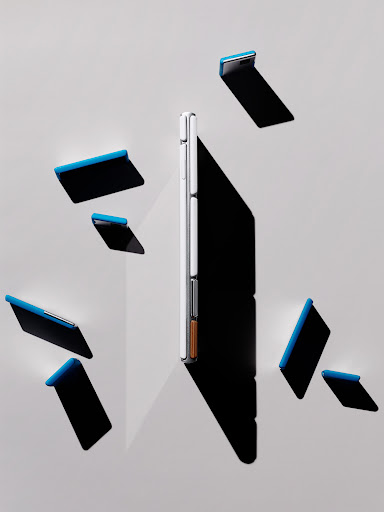 Modern smartphone displayed vertically with shadow and scattered covers on a light grey background creating a technology product still life.