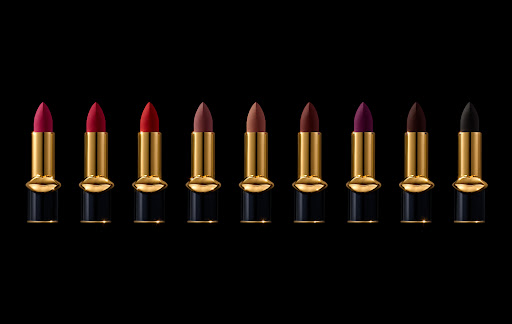 A row of lipstick tubes in varying colors with gold accents and black bases against a black background, product photography for beauty.