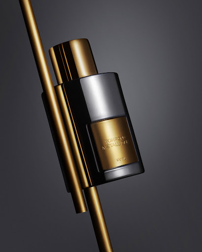 Elegant studio shot of a gold and silver perfume bottle with metallic accents on a gray backdrop, creating a sophisticated beauty aesthetic.