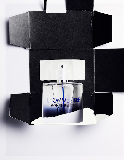 A sleek perfume bottle encased in a deconstructed black box against a white background, highlighting its gradient blue label and minimalist design.