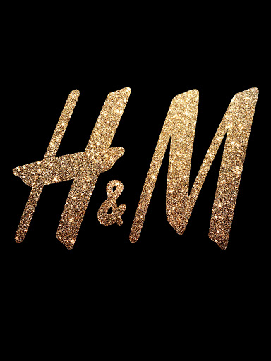 Glittering H&M logo against black backdrop, spotlighting the fashion brand's iconic emblem with a touch of glamour and shine.