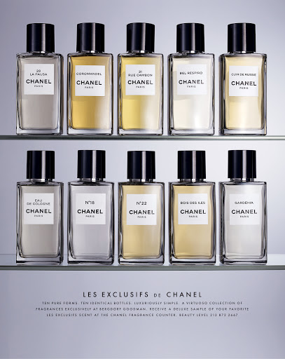 Ten Chanel perfume bottles arranged on two glass shelves against a neutral background, showcasing product presentation and minimalist design.