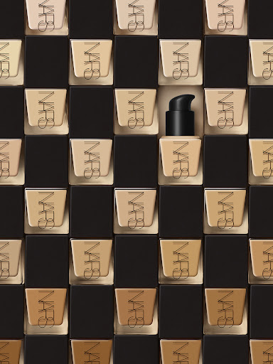 NARS foundation bottles arranged in a grid pattern with varying shades, creating a visually appealing and organized cosmetic display.