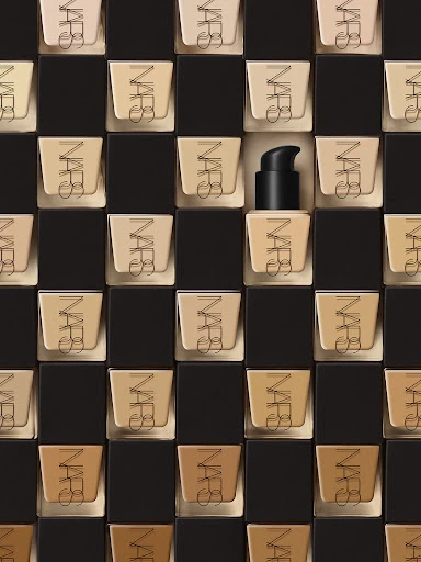 NARS foundation bottles arranged in a grid pattern with varying shades, creating a visually appealing and organized cosmetic display.