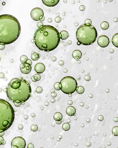 Close-up of green-tinted bubbles with varying sizes on a light background, creating a visually interesting and fresh aesthetic.