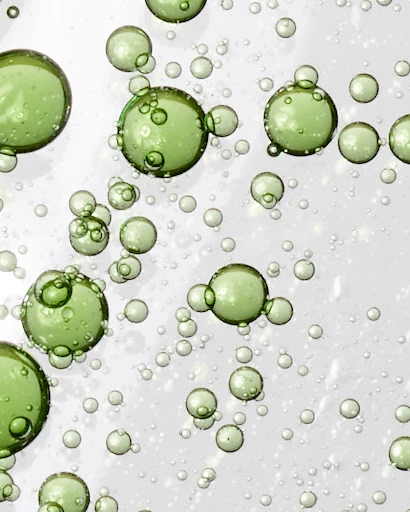 Close-up of green-tinted bubbles with varying sizes on a light background, creating a visually interesting and fresh aesthetic.