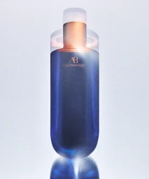 Blue cosmetic bottle with translucent glowing multiple exposure effect against light background