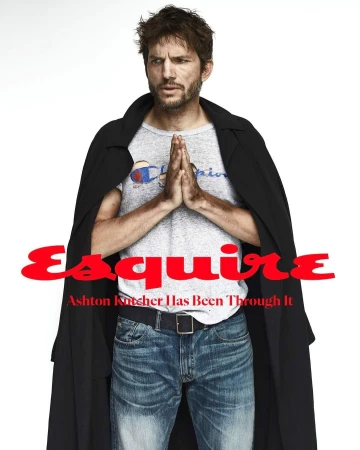 Portrait of Ashton Kutcher wearing a Champion t-shirt, jeans, and black coat with Esquire magazine text overlay on a white background.