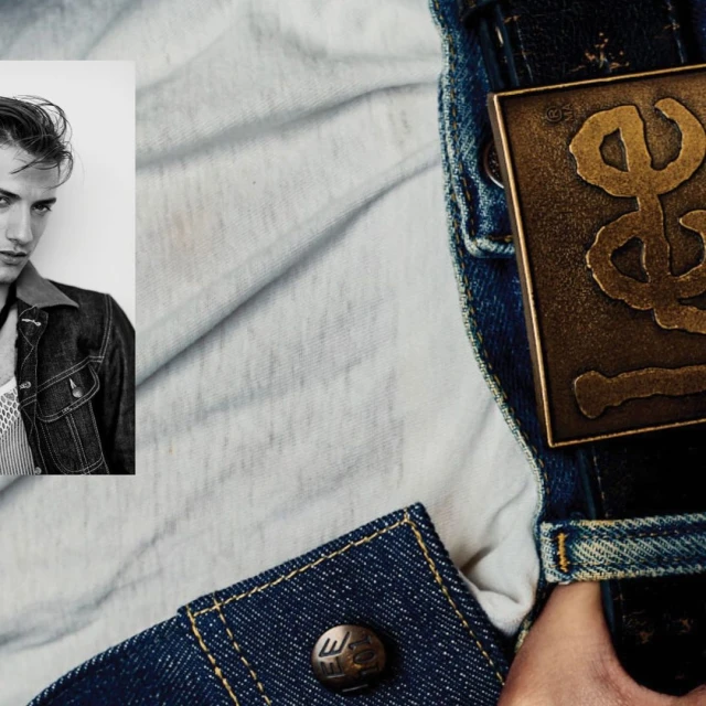 Close-up fashion shot: adult male poses in black and white photo booth-style portrait, wears denim jacket against a washed-out backdrop.