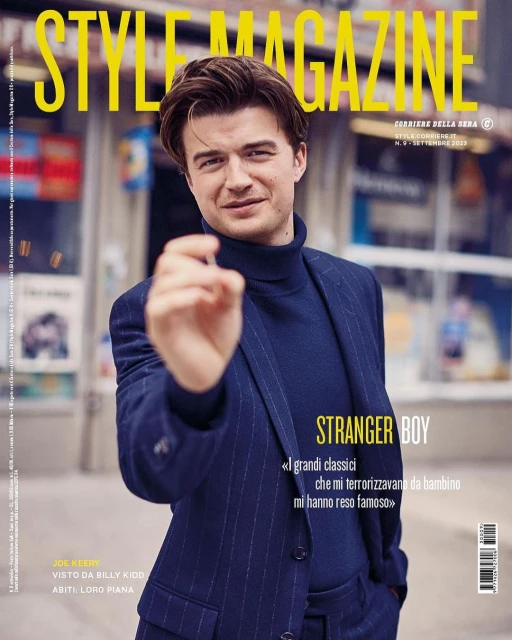 Joe Keery on Style Magazine cover in blue suit and turtleneck, posing in an urban outdoor setting with bright, soft lighting.