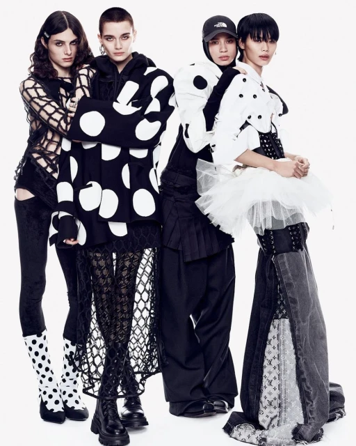 Four models pose in a white studio wearing avant-garde black and white outfits, showcasing unique textures, patterns, and silhouettes.
