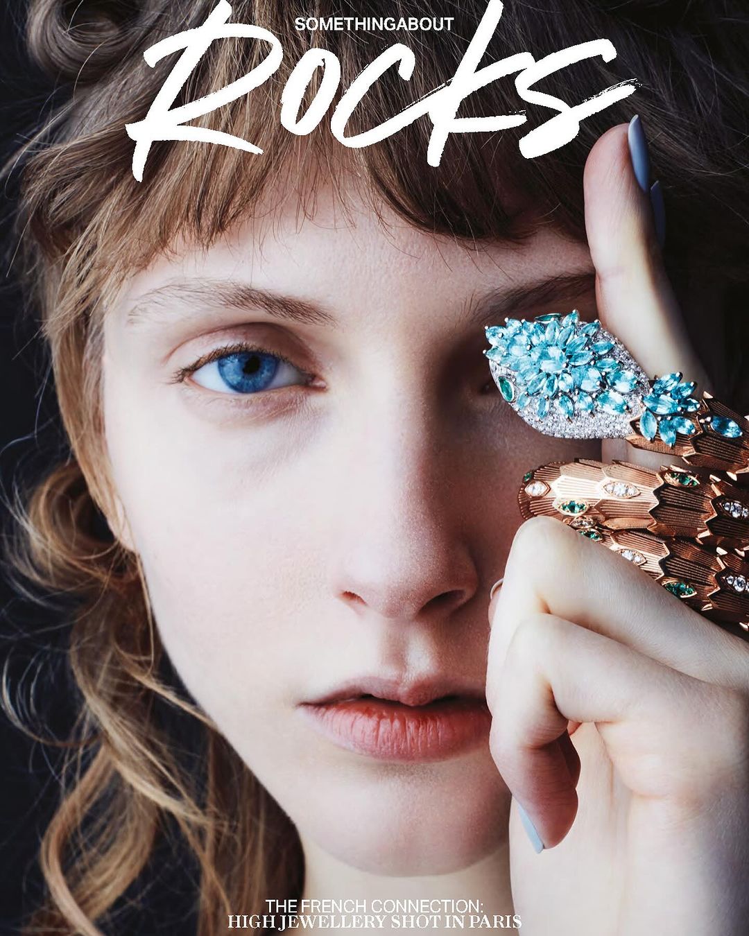 Magazine cover featuring a woman with striking blue eyes and ornate snake-shaped jewellery, with 'Rocks' text overlay.