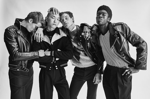 Four young adult men in leather jackets pose in a studio; a black and white fashion editorial with modern rock-and-roll style.