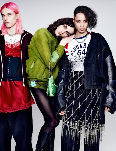 Three fashion models pose in a studio setting with diverse, colorful, and edgy clothing and accessories. Neutral backdrop.