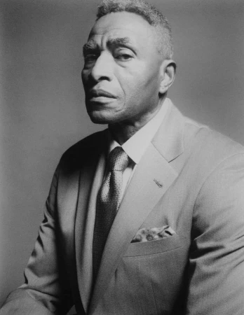 Portrait of an elderly Black man wearing a tailored suit and tie, captured in black and white by Brendan Meadows.
