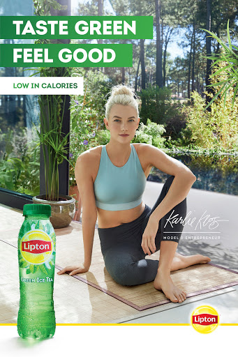 Attractive woman in exercise clothing poses next to a bottle of Lipton Green Ice Tea in an outdoor wellness lifestyle setting.