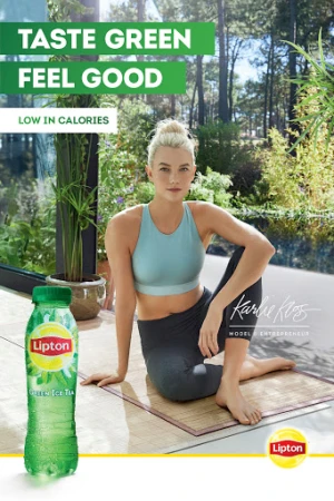 Attractive woman in exercise clothing poses next to a bottle of Lipton Green Ice Tea in an outdoor wellness lifestyle setting.