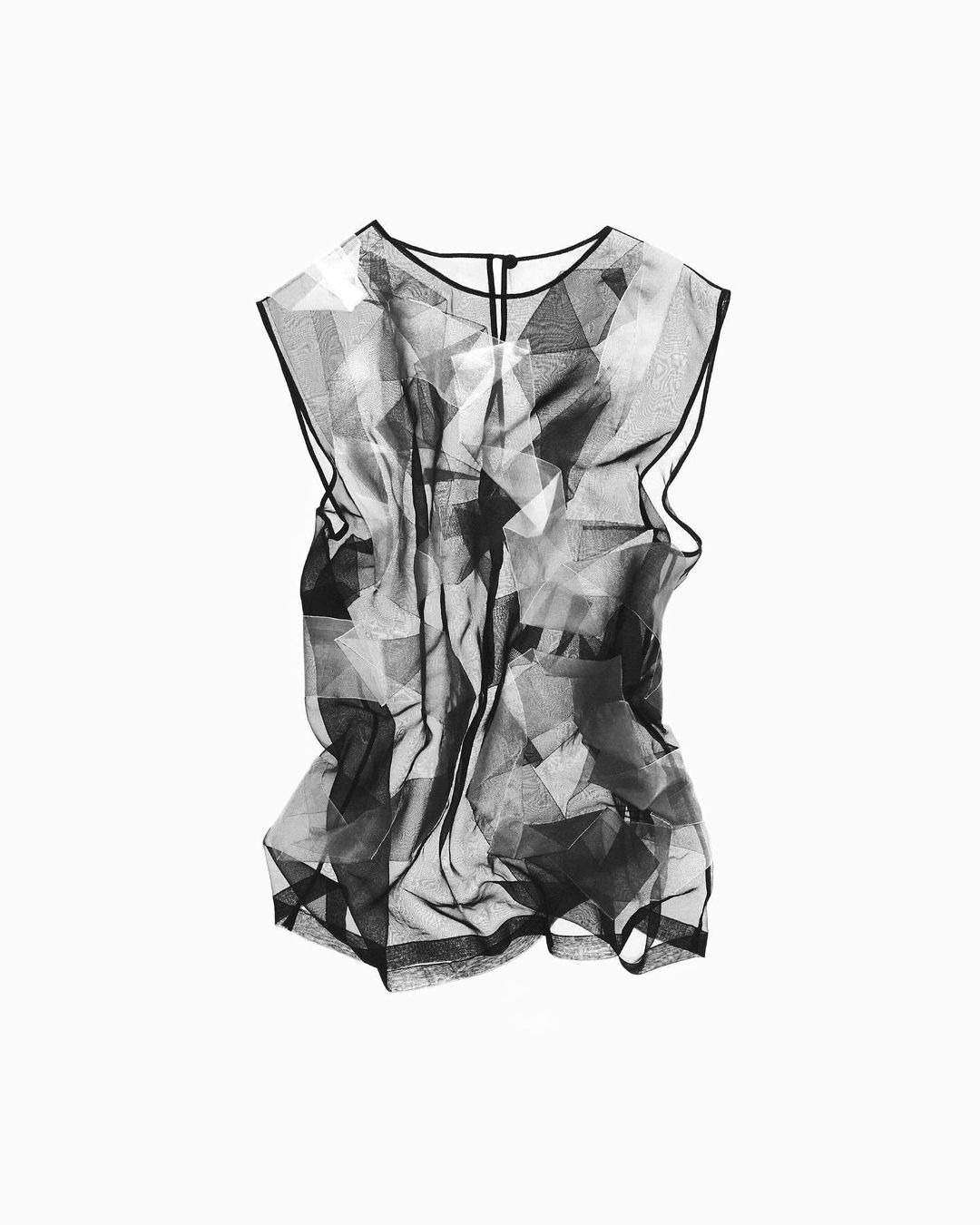 Black and white sheer sleeveless top with geometric pattern isolated against white backdrop in a fashion studio shot for product display.