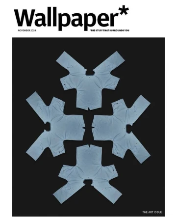 Wallpaper magazine cover featuring an artful arrangement of folded light blue t-shirts against a dark background.