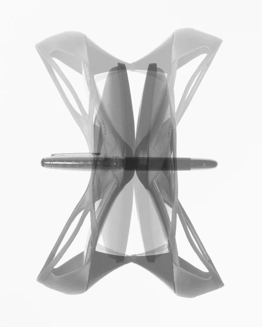 Ghosted image of high heels and a fountain pen on a bright white background with a stark contrast, creating a modern abstract composition.