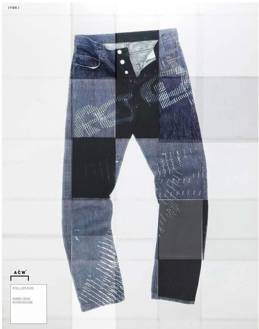 Studio shot of blue denim jeans with button fly and abstract patterning, presented on a white surface with a square grid backdrop.