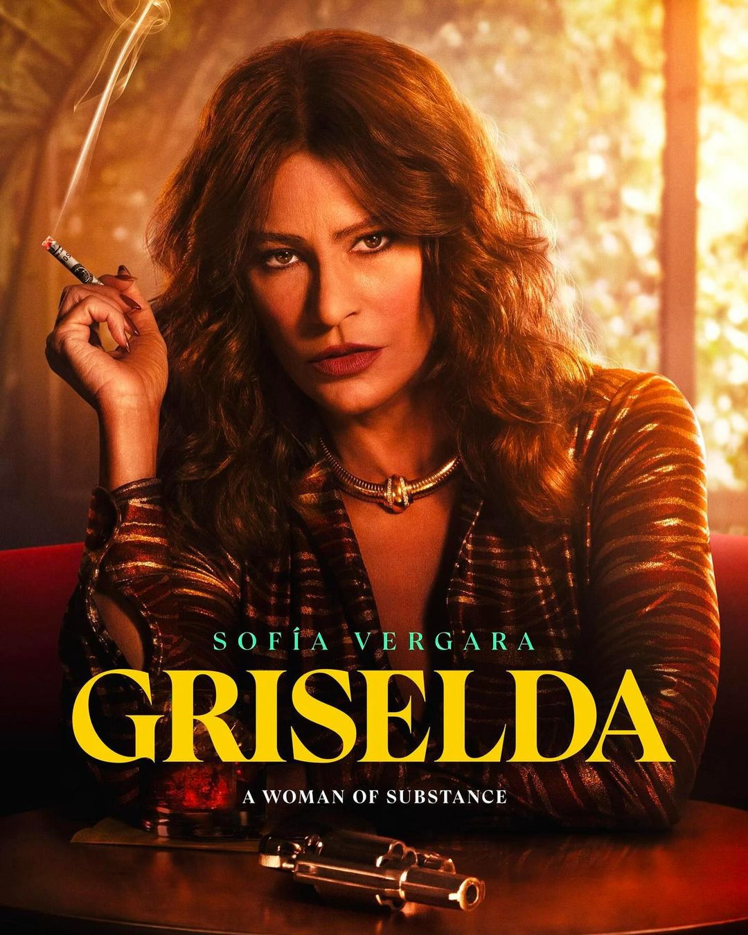 Sofia Vergara as Griselda Blanco holds a cigarette in promotional image for the Netflix series, Griselda, set in a warm-toned indoor environment.