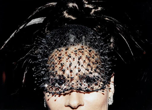 Close-up portrait of a woman wearing an intricate black veiled headpiece with dark textured netting by photographer Jessica Craig-Martin.